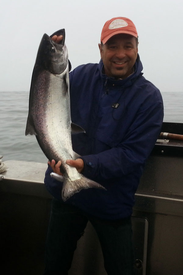 Mr. Al Vargas bringing in a salmon during a trip to Alaska with fellow teacher Mr. Vinnie DiBella.