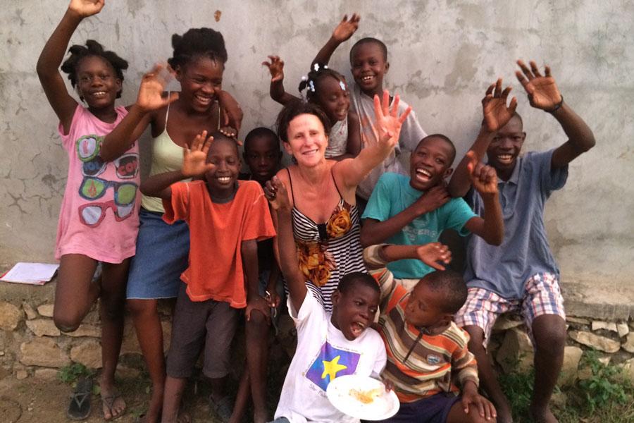 CI teacher Ms. Jackie Hamer waves with some of the children she met on her recent trip to Haiti.